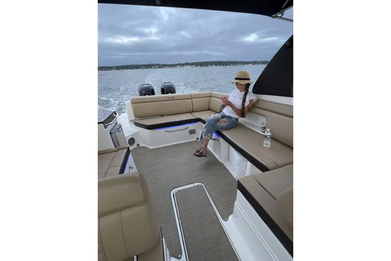 Slide: The Image of 2018 Sea Ray SDX 290 Outboard boat interior with person relaxing on deck. - 9