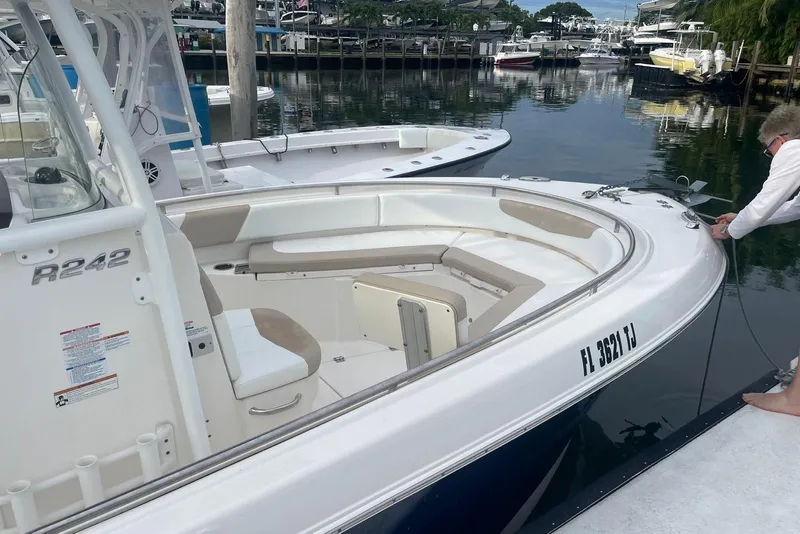 Slide: The Image of 2020 Robalo R242 Explorer boat docked, featuring spacious seating and sleek design. - 2