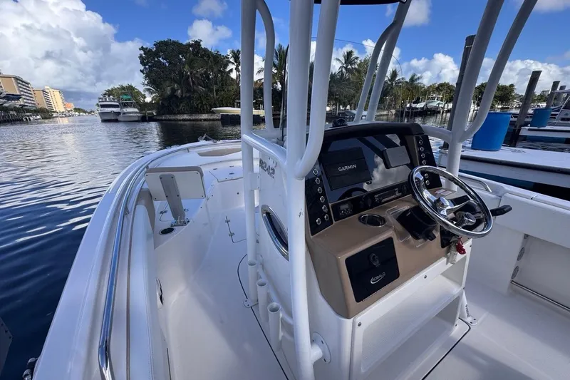 Slide: The Image of 2020 Robalo R242 Explorer boat with Garmin navigation, docked by a scenic waterfront. - 22