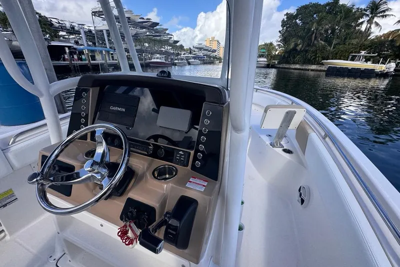 Slide: The Image of 2020 Robalo R242 Explorer boat cockpit with steering wheel and Garmin navigation system. - 23