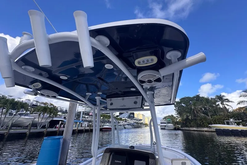 Slide: The Image of 2020 Robalo R242 Explorer boat with rod holders and speakers, docked by a marina. - 26