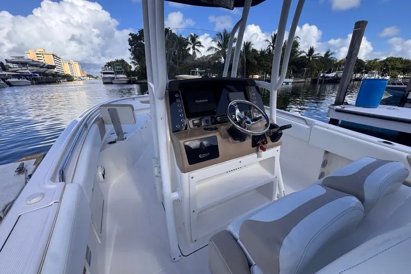 Slide: The Image of 2020 Robalo R242 Explorer boat interior with steering console, docked by waterfront. - 28
