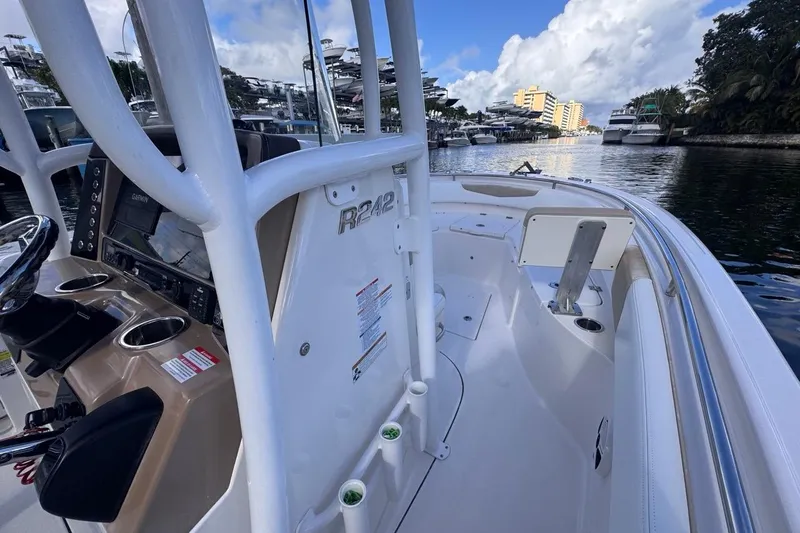 Slide: The Image of 2020 Robalo R242 Explorer boat interior with helm, docked in a scenic marina. - 29