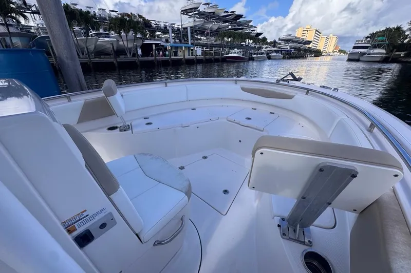 Slide: The Image of 2020 Robalo R242 Explorer boat interior at marina, featuring spacious seating and storage. - 30