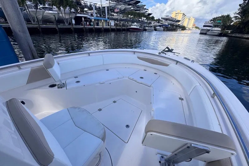 Slide: The Image of 2020 Robalo R242 Explorer boat interior, featuring spacious seating and storage, docked at a marina. - 31
