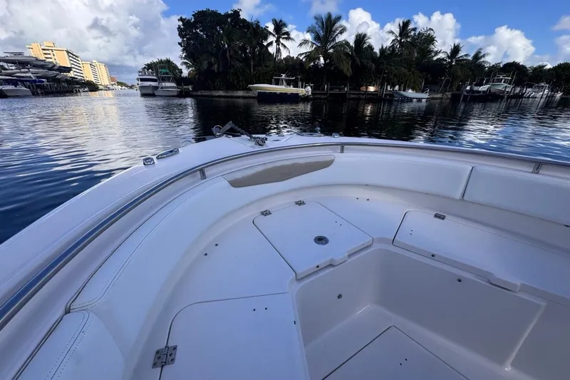 Slide: The Image of 2020 Robalo R242 Explorer boat on calm water, surrounded by palm trees and docked yachts. - 36