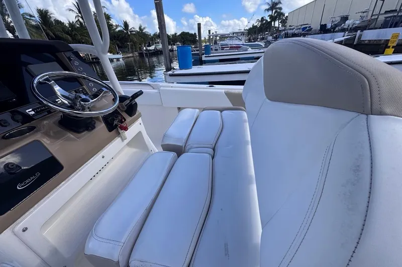 Slide: The Image of 2020 Robalo R242 Explorer boat interior with steering wheel and white seating. - 45