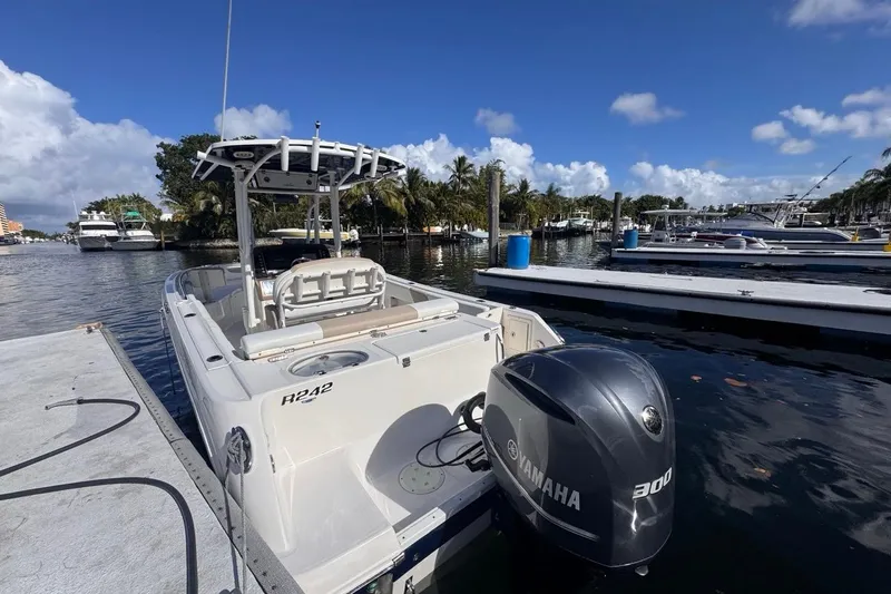 Slide: The Image of 2020 Robalo R242 Explorer boat docked with Yamaha 300 engine, under clear blue sky. - 6