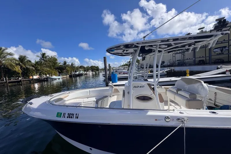 Slide: The Image of 2020 Robalo R242 Explorer boat docked on a sunny day with palm trees in the background. - 9