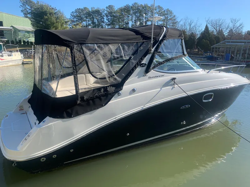 The Image of 2009 Sea Ray 270 Sundancer boat docked in a marina with black canopy. - 0