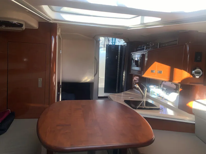 Slide: The Image of Interior of 2009 Sea Ray 270 Sundancer boat with wooden table and kitchenette. - 16