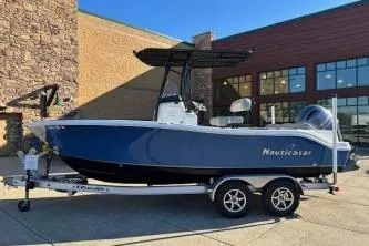 Slide: The Image of 2022 NauticStar 2102 Legacy boat on trailer, parked outside a building. - 14