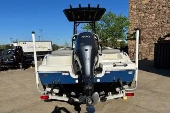 Slide: The Image of 2022 NauticStar 2102 Legacy boat with outboard motor, parked outdoors. - 16
