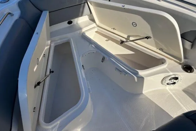 Slide: The Image of 2022 NauticStar 2102 Legacy boat storage compartments open, showcasing spacious interior design. - 17