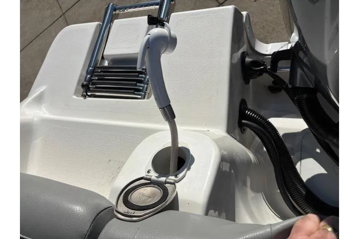 Slide: The Image of 2022 NauticStar 2102 Legacy boat deck with shower hose and ladder. - 18