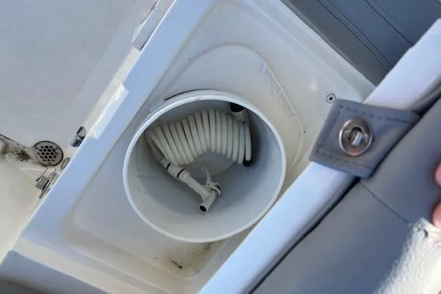 Slide: The Image of Storage compartment with coiled hose on a 2022 NauticStar 2102 Legacy boat. - 9