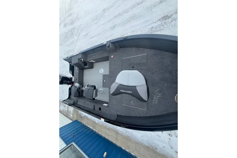 Slide: The Image of 2026 Crestliner 1650 Pro Tiller boat interior with seating and controls, on snowy ground. - 13