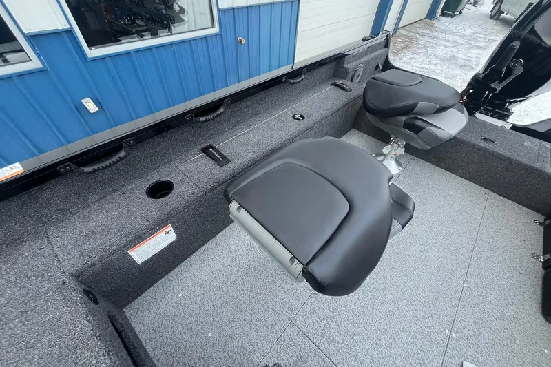 Slide: The Image of 2026 Crestliner 1650 Pro Tiller interior with two swivel seats and carpeted flooring. - 16