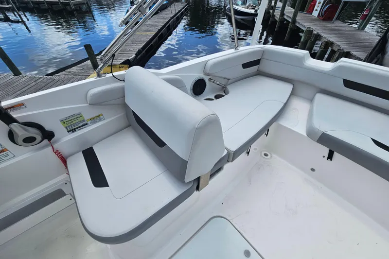 Slide: The Image of 2023 Hurricane SunDeck Sport 188 OB boat interior with white seating and dock view. - 17