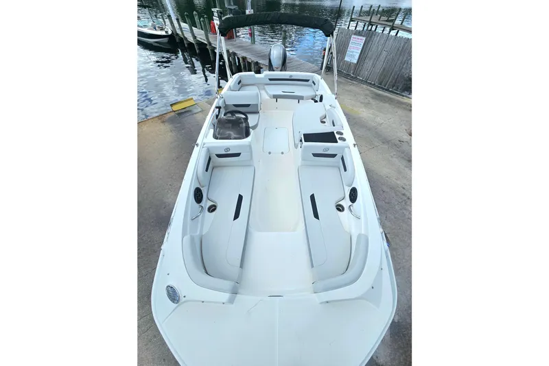 Slide: The Image of 2023 Hurricane SunDeck Sport 188 OB boat with spacious seating, docked by the water. - 8