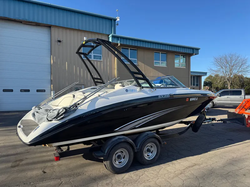Slide: The Image of 2014 Yamaha SX210 boat on trailer in front of building. - 2
