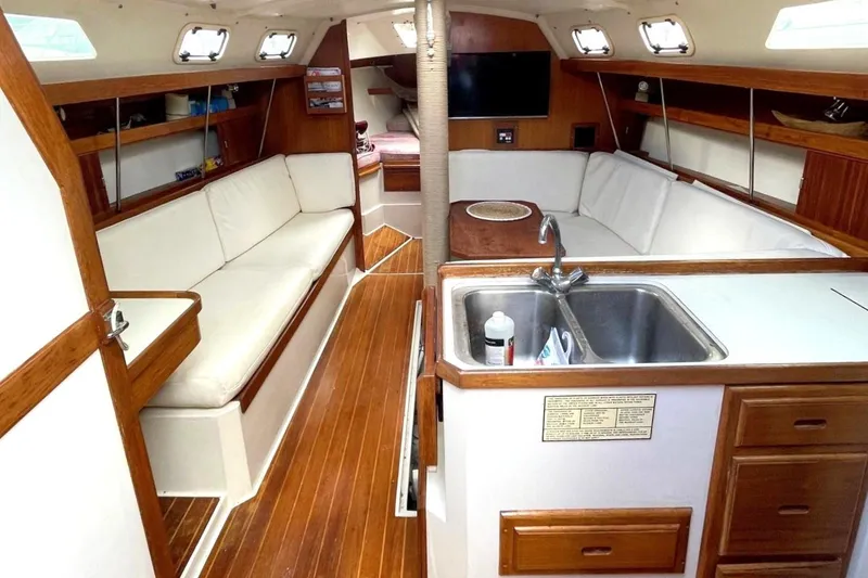 Slide: The Image of Interior of a 1992 Catalina 34 sailboat with wood accents and white seating. - 13