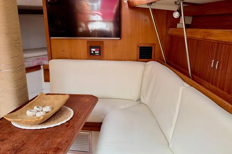 Slide: The Image of Interior of a 1992 Catalina 34 sailboat with white seating and wooden accents. - 17