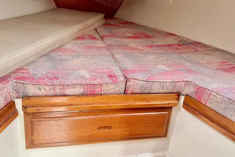 Slide: The Image of 1992 Catalina 34 sailboat interior with patterned cushions and wooden storage drawer. - 19