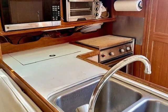 Slide: The Image of 1992 Catalina 34 yacht kitchen with sink, stove, and microwave. - 20