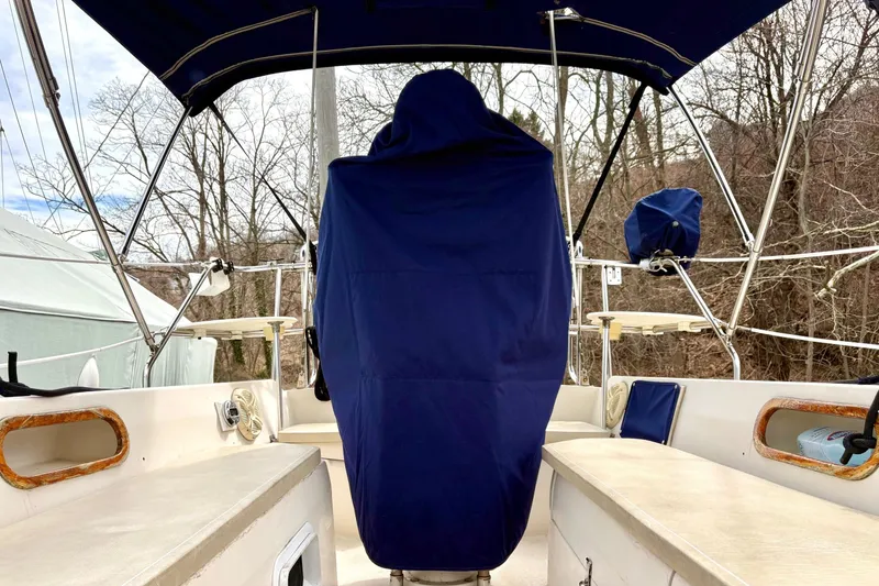 Slide: The Image of 1992 Catalina 34 sailboat cockpit with blue covers and canopy, surrounded by trees. - 8