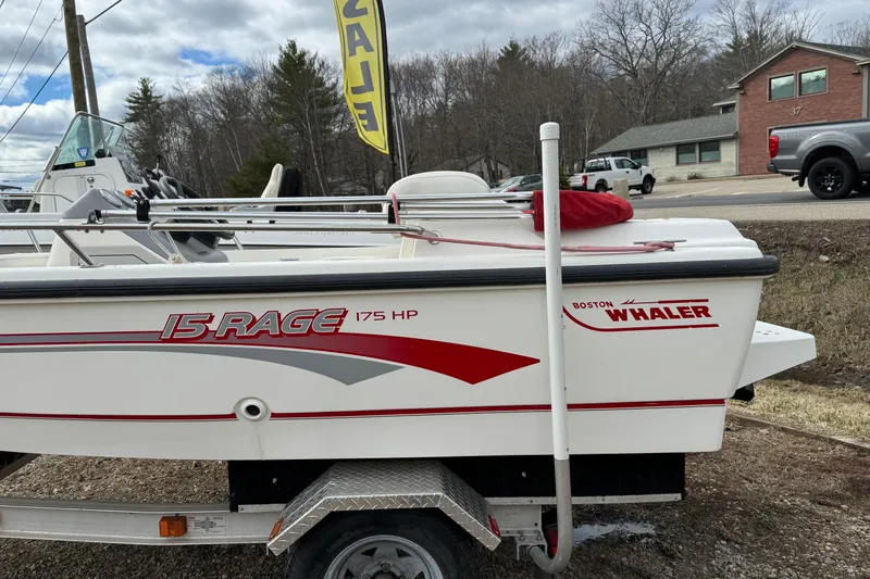 Slide: The Image of 1997 Boston Whaler Rage 15 boat on trailer, side view with branding visible. - 4