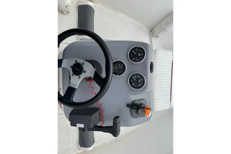 Slide: The Image of 1997 Boston Whaler Rage 15 dashboard with steering wheel and gauges. - 6