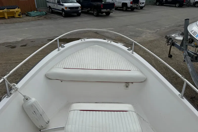 Slide: The Image of 1997 Boston Whaler Rage 15 boat interior with white cushioned seating. - 7