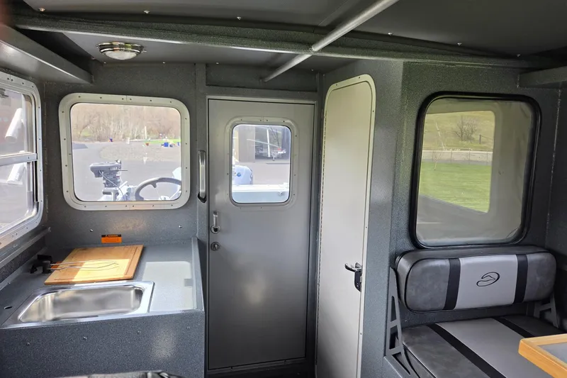 Slide: The Image of Interior of a 2012 Duckworth 28 Offshore boat with kitchenette and seating area. - 15