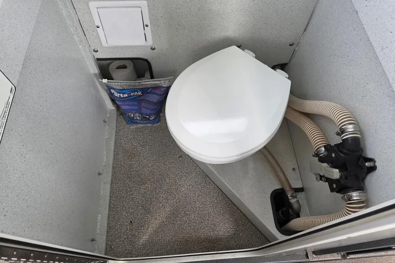 Slide: The Image of Compact marine toilet in a 2012 Duckworth 28 Offshore boat, featuring Porta-Pak and plumbing hoses. - 18