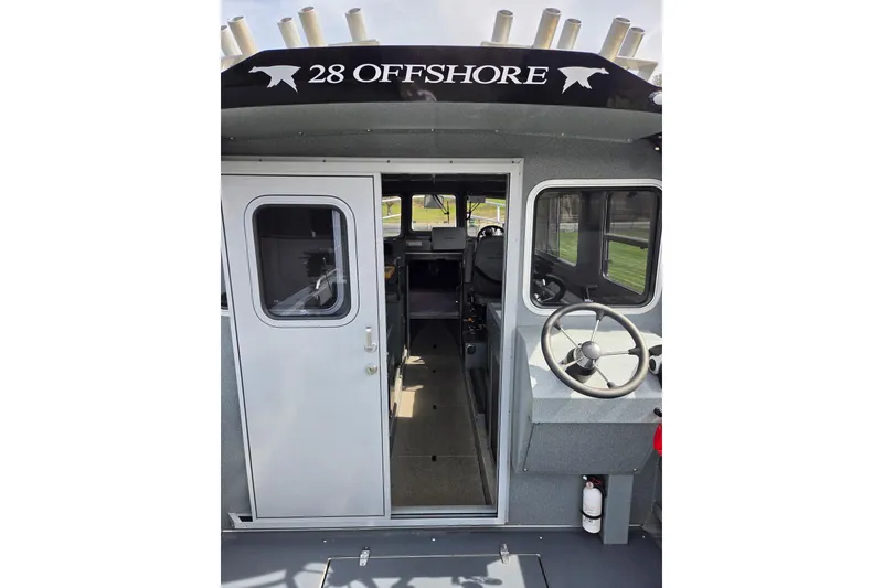 Slide: The Image of 2012 Duckworth 28 Offshore boat interior with steering wheel and cabin entrance. - 2