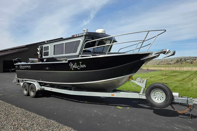 Slide: The Image of 2012 Duckworth 28 Offshore boat on trailer, parked outdoors under clear sky. - 30