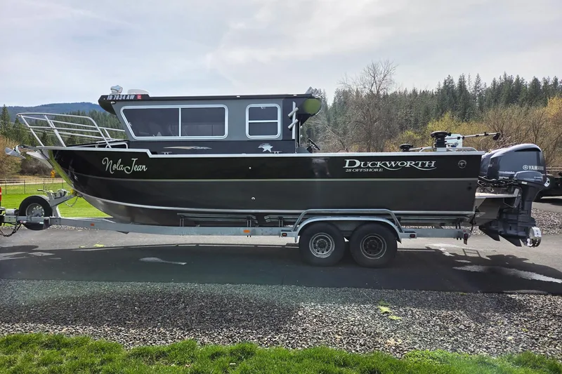 Slide: The Image of 2012 Duckworth 28 Offshore boat on trailer, parked outdoors with scenic background. - 35