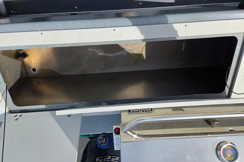 Slide: The Image of Storage compartment on a 2012 Duckworth 28 Offshore boat, featuring a Magma grill. - 36