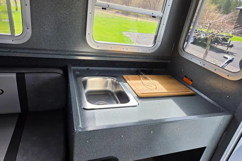 Slide: The Image of Interior of a 2012 Duckworth 28 Offshore boat featuring a compact kitchen area. - 5