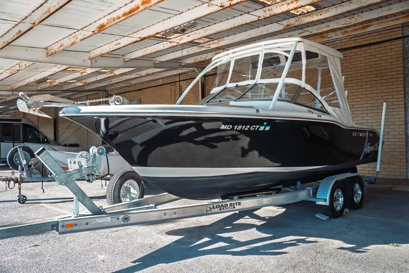 Slide: The Image of 2019 Key West 239 DFS boat on trailer under a metal roof. - 1