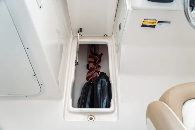 Slide: The Image of Storage compartment in 2019 Key West 239 DFS boat with fins and a flag. - 15