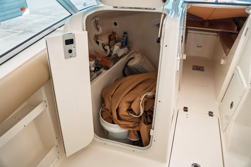Slide: The Image of 2019 Key West 239 DFS boat storage compartment with supplies and equipment. - 16
