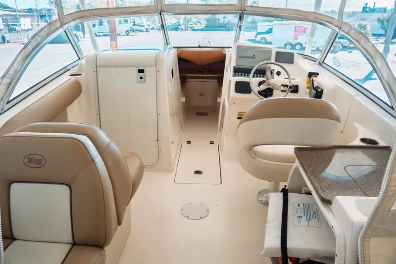 Slide: The Image of Interior of a 2019 Key West 239 DFS boat with beige seating and steering console. - 26