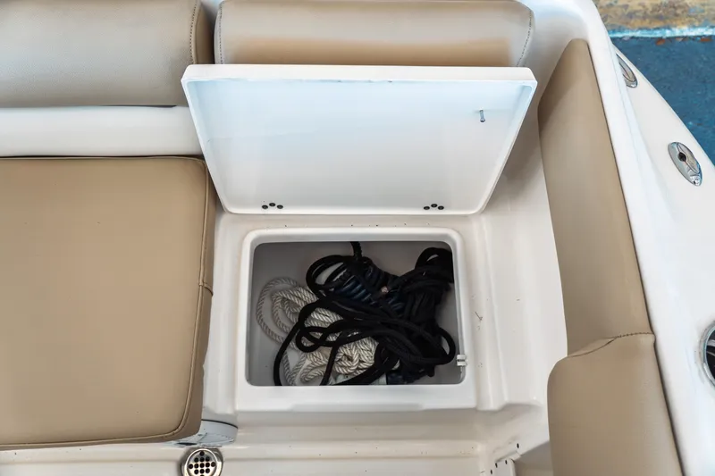 Slide: The Image of 2019 Key West 239 DFS boat storage compartment with ropes, beige seating. - 28