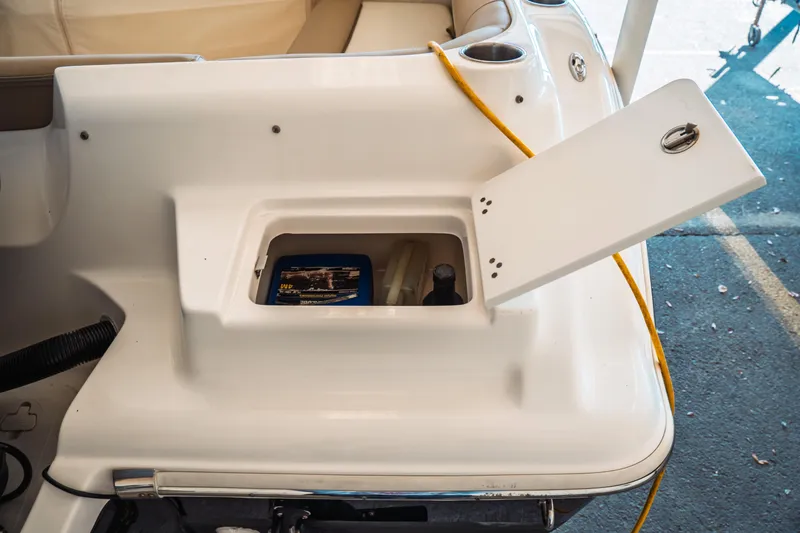 Slide: The Image of Open storage compartment on a 2019 Key West 239 DFS boat, featuring a yellow cable. - 3