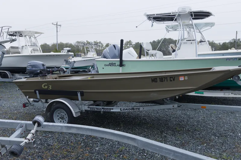The Image of 2025 G3 Gator Tough 1652 VBW boat on trailer, parked in a marina lot. - 0