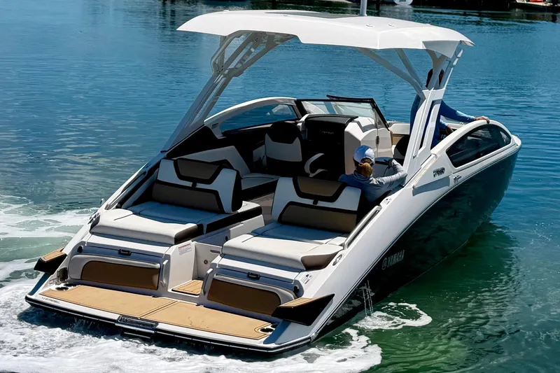 The Image of 2022 Yamaha Boats 275SD cruising on clear water, showcasing sleek design and spacious seating. - 0