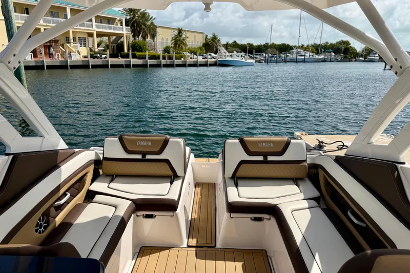 Slide: The Image of Interior view of 2022 Yamaha Boats 275SD, featuring luxurious seating and waterfront backdrop. - 13
