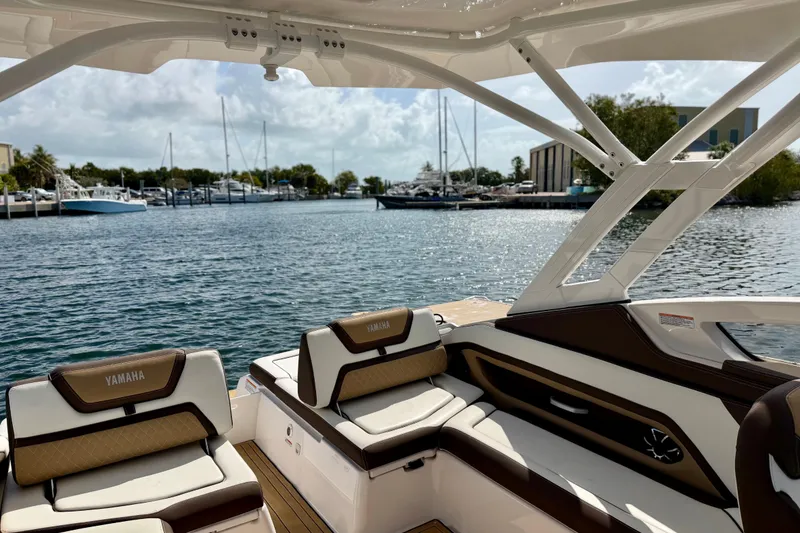Slide: The Image of 2022 Yamaha Boats 275SD interior with marina view, showcasing luxury seating and design. - 15